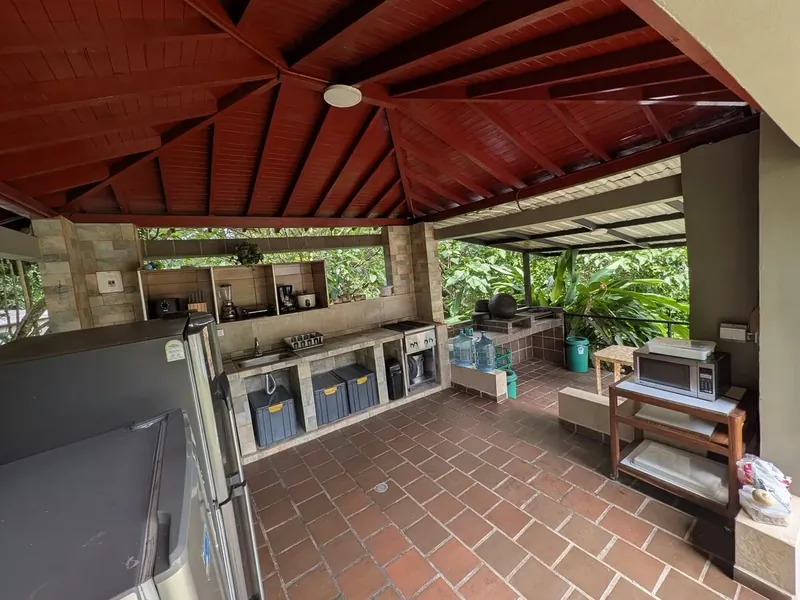 Cocina exterior techada, con nevera y asador